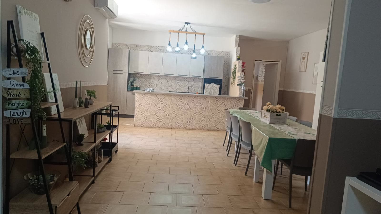 Cucina open space con isola e sala da pranzo nella comunità La Casa di Francesco