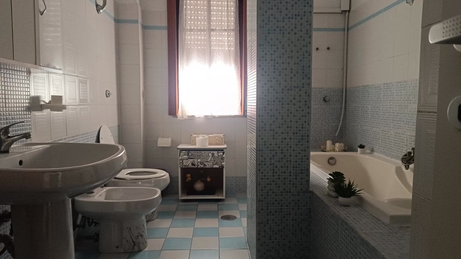 Bagno con vasca rivestita in mosaico celeste nella comunità La Casa di Francesco