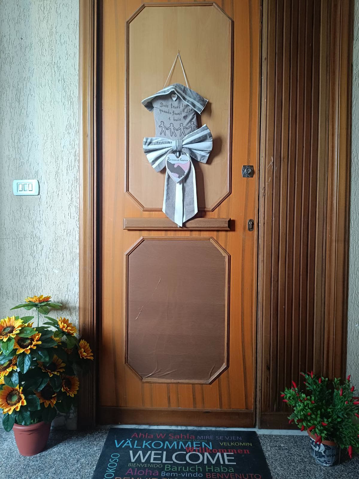 Ingresso della comunità La Casa di Francesco con fiocco decorativo e zerbino di benvenuto